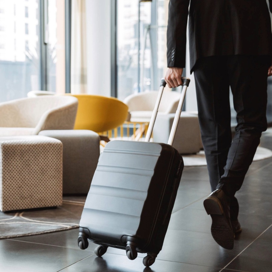 Person läuft mit Koffer durch eine Hotellobby