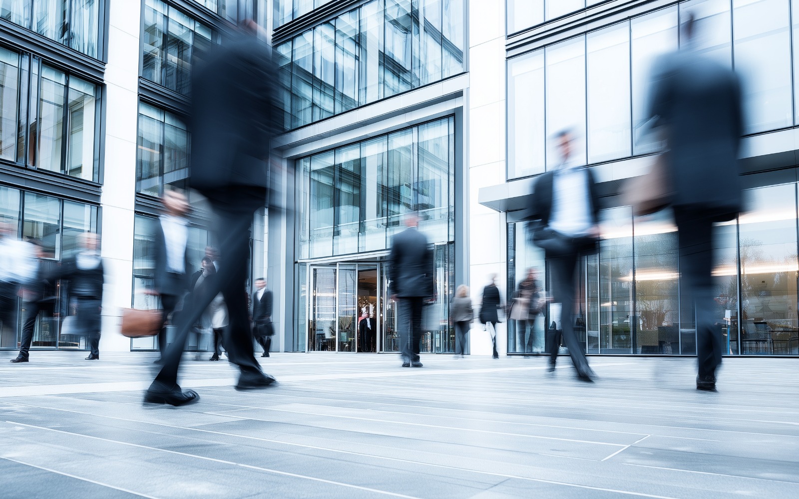 Verschwommenes Bild. Mehrere Mitarbeiter laufen Vor einem Bürogebäude. 